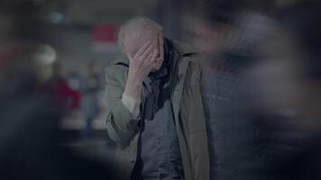 äldre hemlös man lidande från fattigdom ser för hjälp på tåg station video