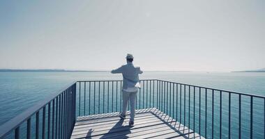 Young Man in Retro Vintage Style Walking on Bridge Road with Lake View video