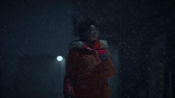 negro hembra persona con Rizado pelo participación luz de una vela en Nevado invierno clima video