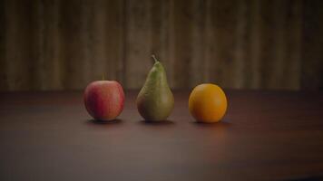 Three fruits an apple, a pear, and an orange displayed on a wooden table video