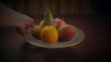 une bol de fruit, comprenant des oranges et rangpur, repose sur une en bois table video