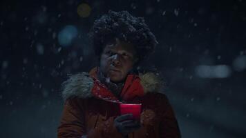 svart kvinna person med lockigt hår innehav levande ljus i snöig vinter- väder video