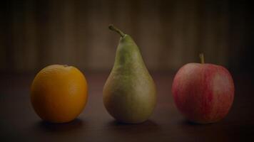 Food items like an orange, a pear, and an apple are placed on a wooden table video