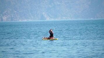 Woman Sup Sea. two woman learns to paddle sup board in open sea ocean on hot sunny day. Summer holiday vacation and travel concept. Aerial view. Slow motion video