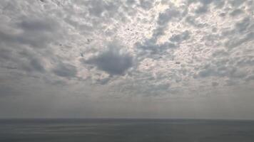 Timelapse fluffy Cumulus clouds moving in bright sunset sky over calm sea. Abstract aerial nature summer ocean sunset, sea and sky view. Vacation, travel, holiday concept. Weather and Climate Change video