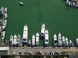 Aerial panoramic view of Balaklava landscape with boats and sea in marina bay. Crimea Sevastopol tourist attraction. Drone top view shot of port for luxury yachts, boats and sailboats. photo