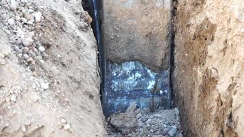 excavatrice creuse une tranchée à allonger tuyaux. proche en haut de un excavatrice creusement une Profond tranchée. un excavatrice creuse une tranchée dans le campagne à allonger une l'eau tuyau. lent mouvement video