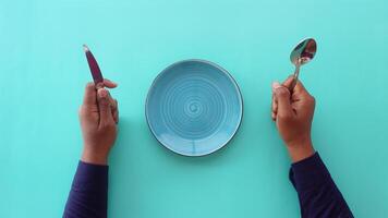 cutlery and empty plate on wooden background top down video