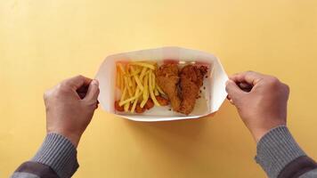 top view of hand pick Crispy fried chicken from a paper box video