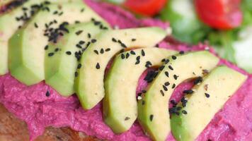 belegd broodje met avocado en hummus Aan bord video