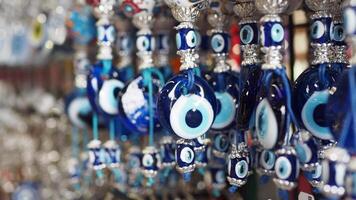 a bunch of blue evil eye keychains hanging on a shelf video