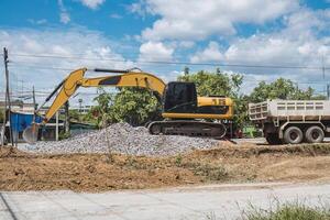 Excavator digging soil and stone on construction site photo