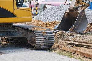 Excavator digging soil and stone on construction site photo