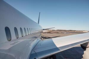 Wing of airplane with windows on runway photo