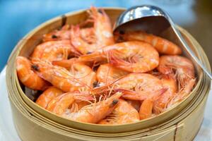 Shrimps heap boiled with scoop in wooden basket photo