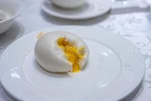 Custard lava cream bun flowing on white plate photo