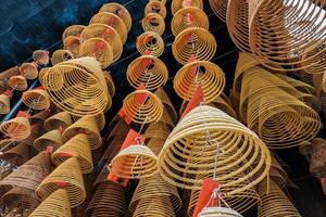 asiático circular incienso ardiente colgar en carril en templo foto