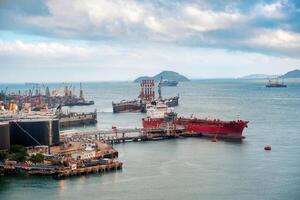 Large carrier cargo ship loading and working industrial crane at the port of an oil refinery photo