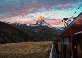 View from train with sunrise over Matterhorn mountain during ride up to Gornergrat station in Zermatt, Switzerland photo