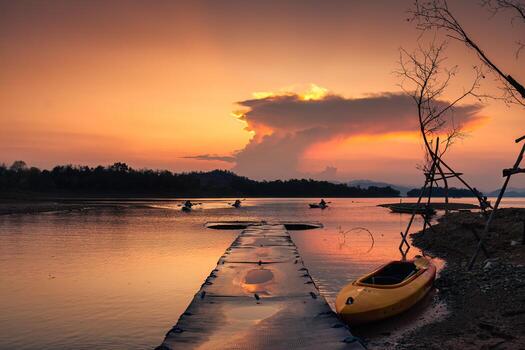 Sunset view of the Kaeng Krachan reservoir with fishing boat and tourist rowing canoe photo