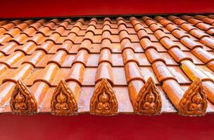 Terracotta tiled roof with carved buddha design photo
