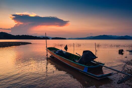 Sunset view of the Kaeng Krachan reservoir with fishing boat and tourist rowing canoe photo