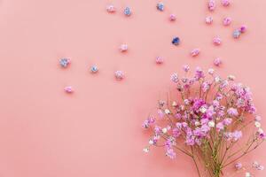 Composition with bouquet of pink flowers on pink background photo