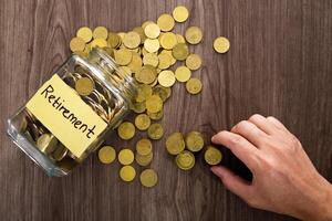 Coin glass jar container on wooden desk, retirement saving concept photo