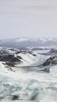 stor snö lappa vänster över på de vulkanisk sten fält av en berg i sommar video