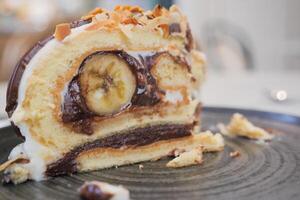 A slice of cake on serveware next to a glass of tea drinkware photo