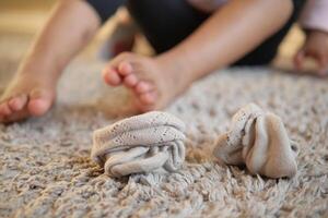 sucio niño calcetines gotas en un alfombra a hogar foto