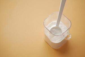 Close up of baby milk powder and spoon on tile background. photo