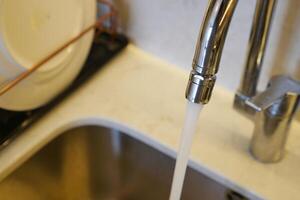 water pouring from a faucet tap slow motion photo