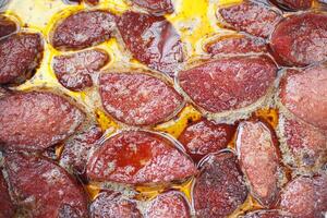 Cooking a dish of breakfast sausage in a pan on a wooden table photo