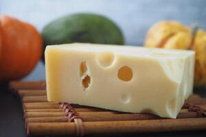 sliced cheese with holes on a chopping board on table photo