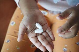 close up of medical pills on palm of child hand photo