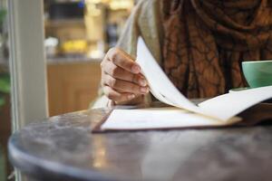 women hand reading a food menu at cafe. photo