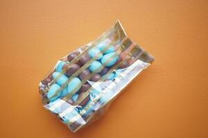 round shape chocolate candy in blue and brown color in a plastic packet photo