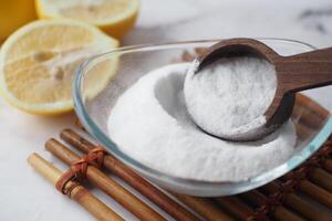 Baking soda and whole lemon on table photo