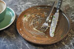 An empty dirty plate with a fork. photo