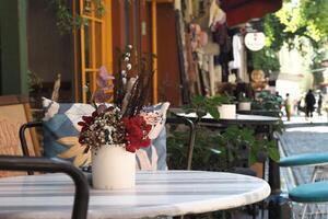 Table outside restaurant adorned with vase of flowers photo