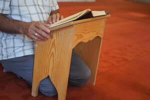 musulmán hombre mano participación santo libro Corán a mezquita foto