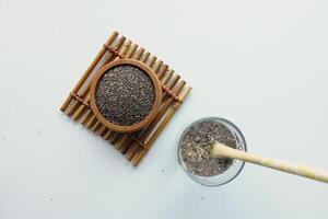 chia semillas en de madera bol. superalimento en un amarillo antecedentes foto