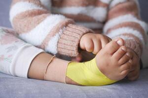 elástico terapéutico amarillo cinta aplicado a niño pierna. kinesio grabando terapia para lesión foto