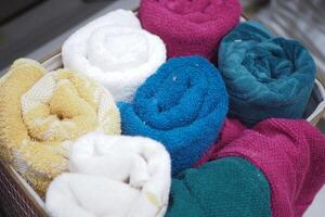 A storage basket made of wood filled with an assortment of towels photo