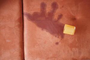 cup of coffee spilled on gray color sofa photo