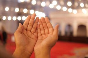 Muslim young woman in hijab is praying in mosque. photo