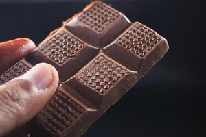 holding a dark chocolate candy photo