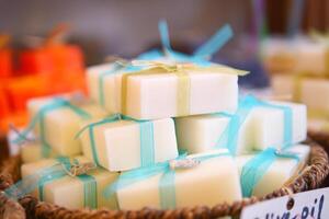 A stack of white soaps with blue ribbons in a basket photo