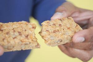 hand cracking a oat protein bar photo